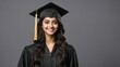 © Tom - A cheerful young woman in graduation attire with a black gown and cap, smiling confidently.