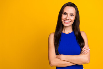 Poster - Photo of adorable confident woman wear blue top arms crossed empty space isolated yellow color background