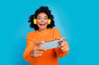 © deagreez - Photo portrait of lovely young lady play mobile game excited face wear trendy knitwear orange garment isolated on blue color background