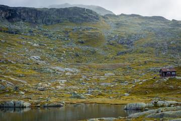 Wall Mural - Wooden hut in the Norwegian  mountains, moody landscape in the trail for Trolltunga