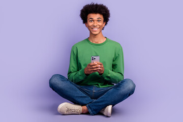 Poster - Full length photo of cool positive guy wear green pullover chatting instagram twitter telegram facebook isolated purple color background