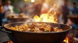 Fototapeta Uliczki - Closeup of a large pot of traditional food being prepared over an open flame at a cultural festival celebration.