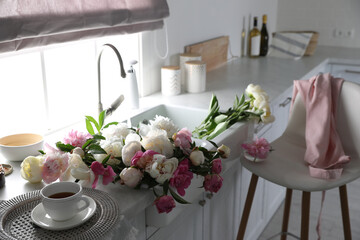 Canvas Print - Beautiful peonies and cup of tea on kitchen counter