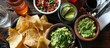 A bird's eye perspective of guacamole, chips, and salsa.