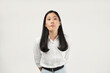 © Illhamt - Pouting with slightly puffed cheeks, an Asian woman in white conveys displeasure and thoughtfulness in a workplace setting, showing reflective and reserved emotions