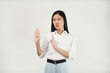 © Illhamt - An Asian woman in a white blouse makes a 'stop' gesture with her hand while looking serious. Set against a plain white background, she exudes a cautious demeanor.
