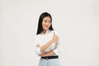 © Illhamt - An Asian woman in a white blouse gives a thumbs-up with a cheerful smile. The white background emphasizes her optimism and professionalism in a business setting.