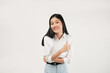 © Illhamt - An Asian woman in a white blouse gives a thumbs-up with a cheerful smile. The white background emphasizes her optimism and professionalism in a business setting.
