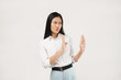 © Illhamt - n Asian woman in a white blouse crosses her hands in a determined gesture. She portrays confidence and focus against a plain white background.