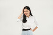 © Illhamt - An Asian woman in a white blouse poses confidently with her hand on her head and a smile. She radiates positivity and approachability in a minimalist white setting.