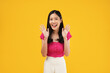 © Illhamt - Excited asian woman shout out loud wow with hands on isolated background. Happy shocked face female wow promotion advertising concept. Isolated on yellow background