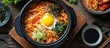 Traditional Korean noodle pot filled with spicy Korean instant noodle, garnished with egg yolk, chilli, veggies, and kimchi.