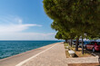 Tranquil charm of empty promenade nestled in Portoroz, offering picturesque vista of glistening Adriatic Sea. Strolling along a beautifully paved walkway along Slovenian coastline of the Gulf of Piran
