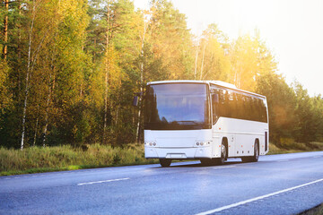Wall Mural - white coach bus driving on autumnal highway. copy space.