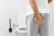 Man suffering from hemorrhoid in rest room, man has diarrhea holding his butt in toilet, diarrhea constipation. Men have diarrhea and are looking for shit.