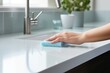 A pristine kitchen counter being cleaned with a cloth