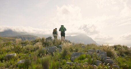 Wall Mural - back of couple hiking, walking on mountains and travel for adventure, wellness and health in nature 