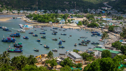 Wall Mural - Wooden boats and tourist boats are packed close together in the clear blue water of Vinh Hy Bay, Phan Rang, Ninh Thuan.