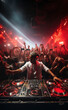 © Tjeerd - dj with dj set plays set on concert in bright stage lights. Professional disc jockey playing electronic music on festival in night club