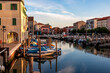 Scenic view of peaceful canal Vena at sunrise in charming town of Chioggia, Venetian Lagoon, Veneto, Italy. Small boats floating in calm water. Enchanting reflections create atmosphere of tranquility