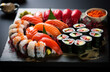 A plate of delicious Japanese sushi and rolls prepared by a seafood restaurant chef on a black background