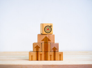 Poster - Target icon on top of wooden cube blocks stack as pyramid shape with rise up arrows on white background. Business goal process, Growth marketing, profit, investment, economic improvement concepts.