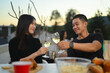 © Prathankarnpap - Young Asian couple having fun at a summertime rooftop party during sunset.