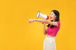 © Illhamt - An Asian woman points forcefully with a megaphone, expressing urgency and assertiveness against a bold yellow background.