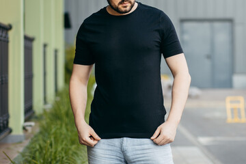 Young stylish bearded man  in a black T-shirt and sunglasses. Street photo