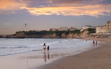 Wall Mural - Biarritz, France. People walking along the beach and enjoying sunset.