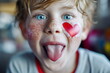 Fun creative valentine's day card. Boy with heart-shaped stickers on his face is showing his tongue and making a face