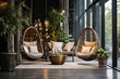 © Margarita Vais  - interior of a modern place to relax near a large window with hanging wicker chairs and a lot of plants around
