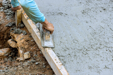 Canvas Print - Leveling of new concrete pavement using special working tool by mason worker at construction site