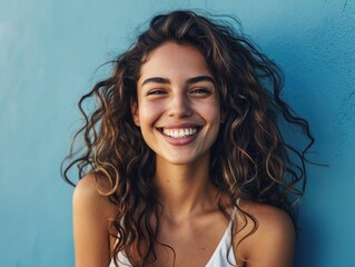 Wall Mural - Beautiful woman smiling on blue background