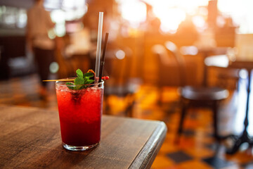 Cold summer red berry drink glass on table in indoor cafe