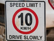 © Romane - Panneau de signalisation routière sale, limitation de vitesse à 10 km/h en anglais