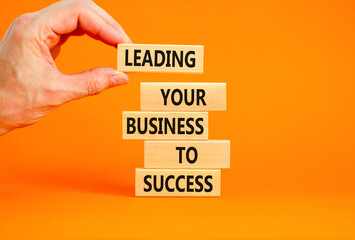 Wall Mural - Leading your business to success symbol. Concept words Leading your business to success on wooden blocks. Beautiful orange table orange background. Leading your business to success concept. Copy space