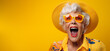 Le cri d'une vieille femme portant des lunettes et un chapeau, arrière-plan orange, image avec espace pour texte.
