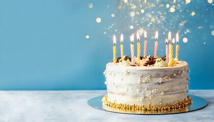 Wall Mural - birthday cake isolated on a blue background birthday party decorated cake with candles and sparkles copy space