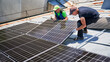 Workers building solar panel system on metal rooftop of house. Two men installers installing photovoltaic solar module outdoors. Alternative, green and renewable energy generation concept.