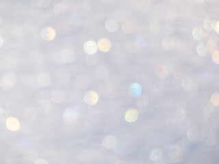 Wall Mural - Artistic, shiny, purposely blurred background with white and colorful bokeh effect of snow in sunlight