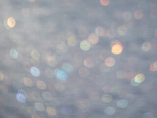 Wall Mural - Artistic, shiny, purposely blurred background with white and colorful bokeh effect of snow in sunlight