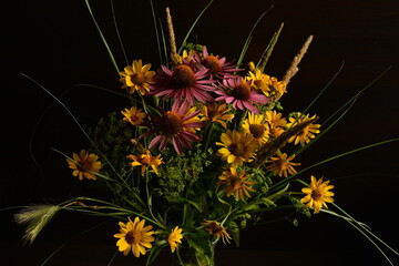 Wall Mural - A bouquet of flowers collected in the wild in a simple glass vase Isolated on a black background