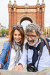 © Xavier Lorenzo - Vertical photo. Mature married couple looking at city map during travel vacation in Barcelona. Active senior people and holidays concept.