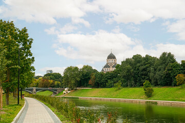 Wall Mural - View of park with river, green trees and church