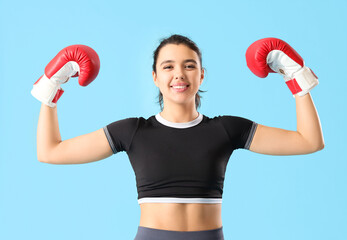 Sticker - Young woman in boxing gloves on blue background