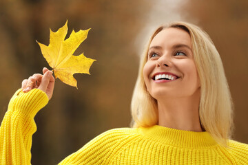 Sticker - Portrait of happy woman with autumn leaf outdoors