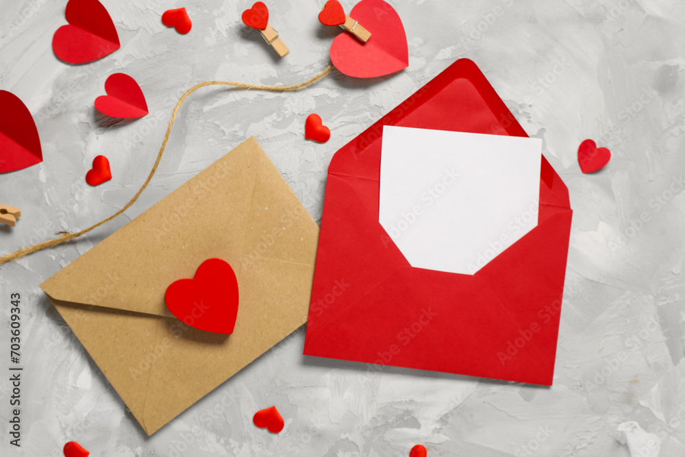 Composition with envelopes, blank card and paper hearts on grunge background. Valentine's Day celebration