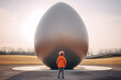 kid standing in front of giiant egg, kid standing in front of egg, big egg, giant egg, sculpture