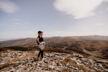 Wall Mural - woman on mountain peak looking in beautiful mountain valley in autumn. Landscape with sporty young woman, blu sky in fall. Hiking. Nature